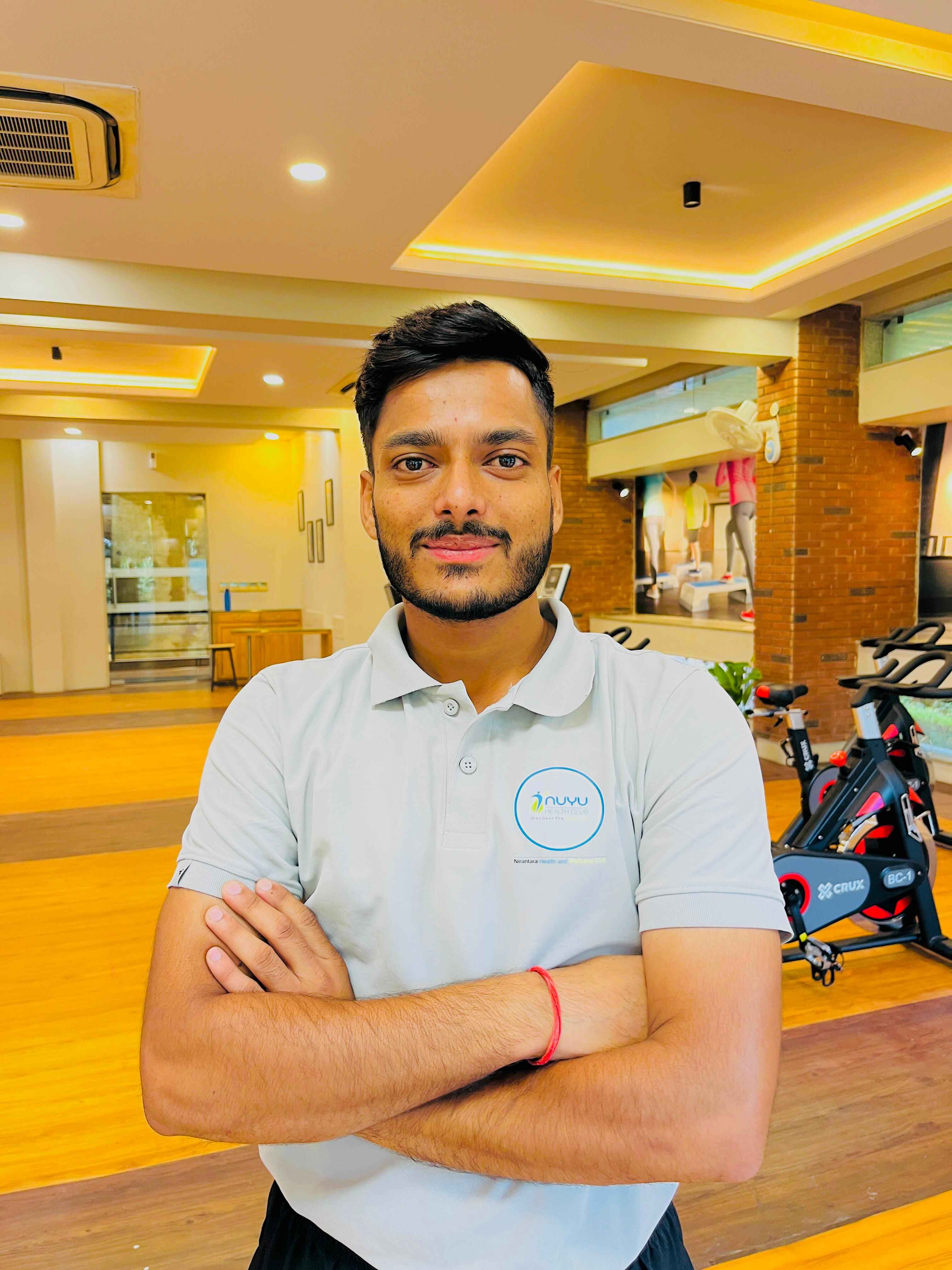 Qualified strength and balance coach helping clients at luxury gym Vaishali Nagar